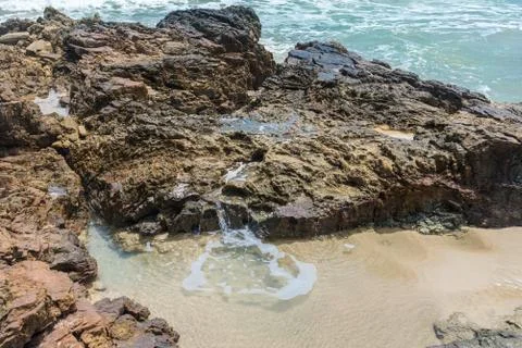 Rocks by the beach with waves splahes 库存照片