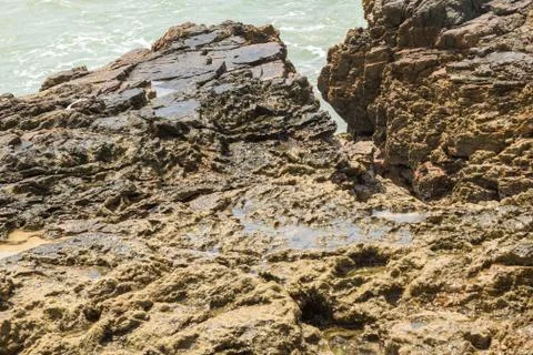 Rocks by the beach with waves splahes Stock Photos