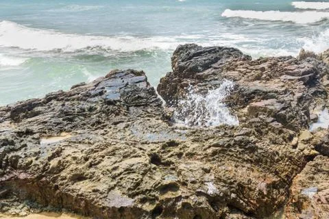 Rocks by the beach with waves splahes Stock Photos