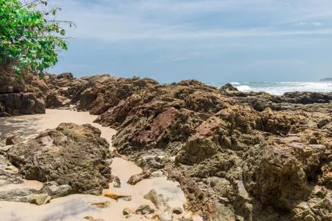 Rocks by the beach with waves splahes Photos