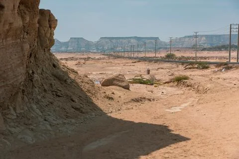 Rocks casting shadow in front with a road and a table mountain in back Stock Photos