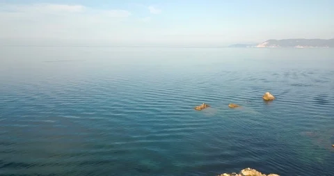 Rocks by the cliffs on the coastline emerging from the sea Stock Footage 108113658
