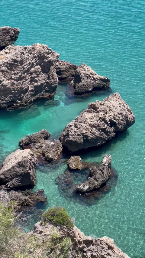 Rocks by the coast of a turquoise sea Stock Footage 336971836