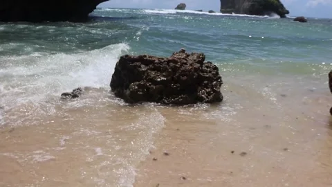 Rocks during big waves on the edge of a beautiful beach Stock Footage 262694858