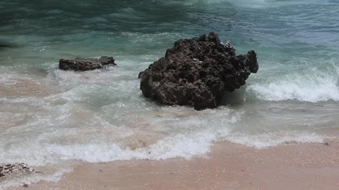 Rocks during big waves on the edge of a beautiful beach Stock Footage 262694904