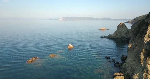 Rocks emerging from the sea water by the cliffs Stock Footage 108113073