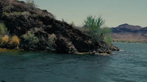 Rocks extend into a deep blue desert lake Stock Footage 241496213