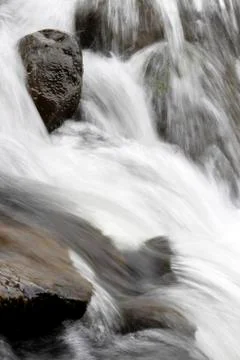 Rocks in fast flowing stream Stock Photos