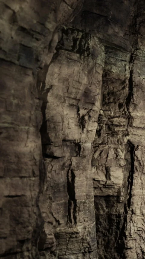 Rocks form a rough surface in a cave showing dark textures and shapes Stock Footage 331749745