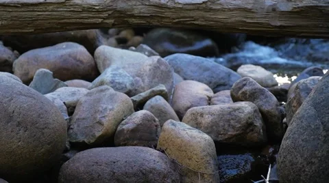 Rocks with log on top and small rapids behind 스톡 동영상 62423585