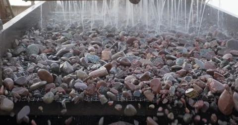 Rocks move through water vibrating screen. Crushing screening plant. Screening Stock Footage 293504635