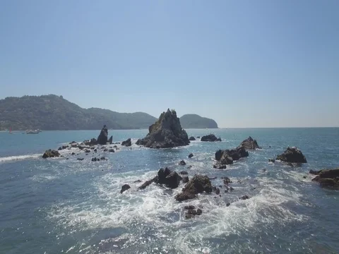 Rocks in Ocean Beach Aerial Flyover Stock Footage 77876013