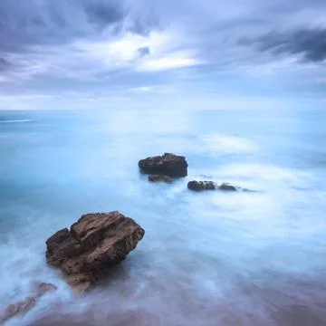 Rocks in a ocean waves under cloudy sky. bad weather. Stock Photos