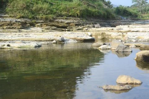 Rocks on the Riverside with Reflection in The Water Stock Photos