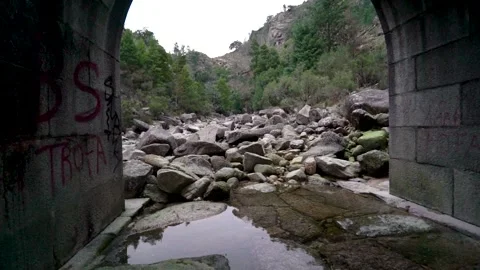 Rocks in shallow riverbed from under stone bridge in Portuguese National Park Stock Footage 264090195