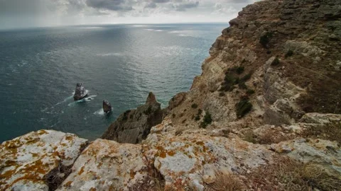 Rocks in the shape of a tooth sticking out in the middle of the sea, Cape Stock Footage 220999080