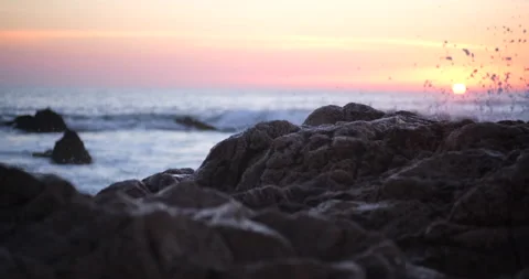 Rocks on shore of beach at sunset. Pan right. Shallow depth of field. Stock Footage 168651668