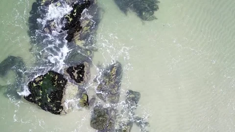Rocks on the shore of a beach with the waves of a calm sea, aerial view fro.. 스톡 동영상 289735396