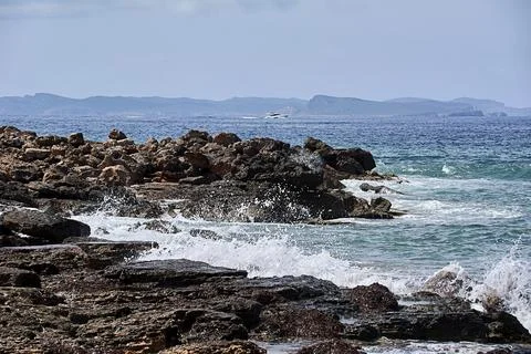 Rocks on the shore hit by the wave Stock Photos