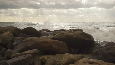 On rocks on the shore a wave breaks slow mo Stock Footage 81403711