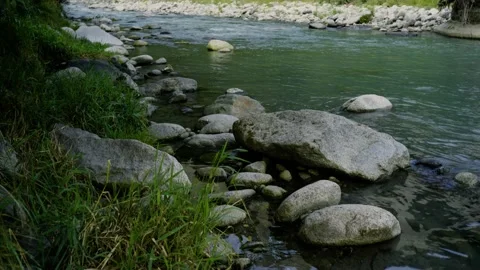 Rocks in a small river underneath a bridge Video stock 204030415