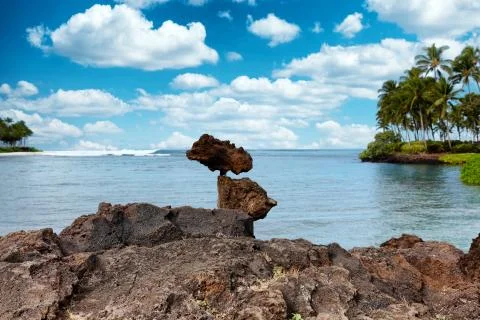 Rocks stacked vertically with ocean waves in background Stock Photos
