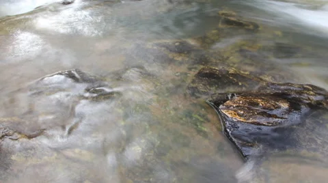Rocks in stream with smooth flowing water Stock Footage 65264603