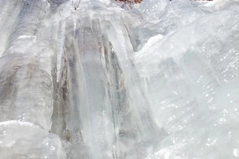 Rocks under ice layers and phantasmagoric ice shapes, frozen leaves, Czech. Stock Photos