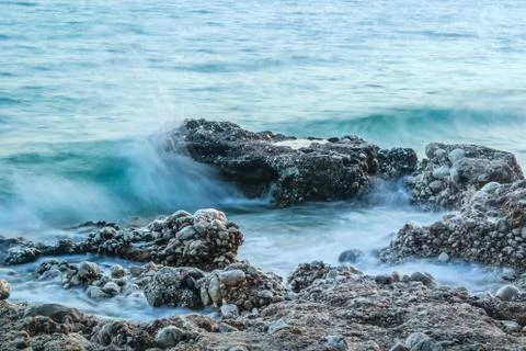 Rocks in the waves, blue sea, shoreline Stock Photos