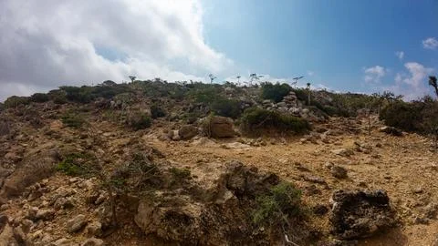 Rocky arid hillside under dramatic clouds and blue sky Stock Photos