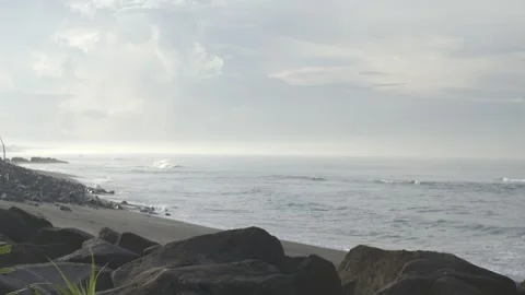 A rocky beach with a calm ocean in the background Stock Footage 278564595