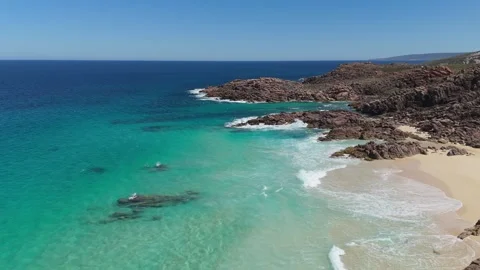 Rocky beach with clear blue ocean and gentle waves Stock Footage 345654237
