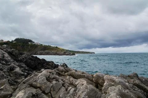 Rocky beach with gray clouds after the storm Stock Photos