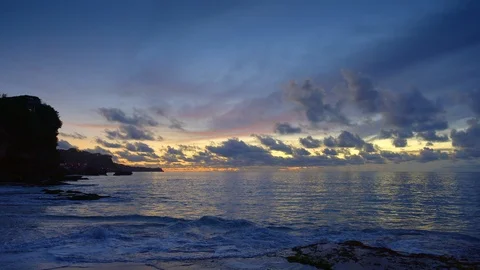 Rocky beach with high tide waves and dark blue water after sunset Video stock 115033928