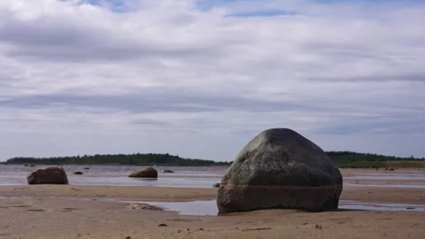 Rocky beach landscape with large boulder and cloudy sky Stock Footage 346047339