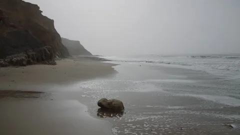 A rocky beach with a large rock on it Stock Footage 298246799