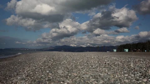 Rocky beach with mountains and cloudy sky by sea Stock Footage 331199891