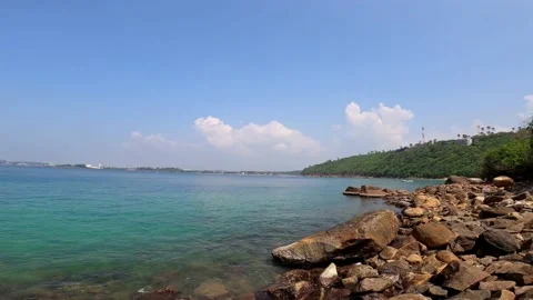 Rocky beach pan shot with full aerial coverage with clear blue sky Stock Footage 239124228