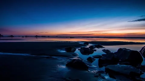 Rocky beach reflection at colorful twilight wide shot Stock Footage 342396078
