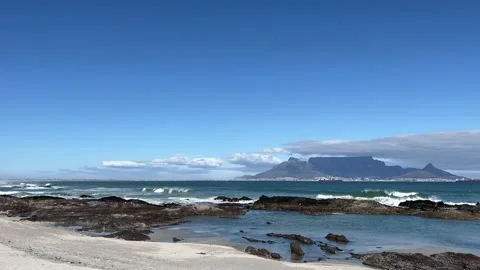 Rocky beach shoreline with  rolling waves and views of Table Mountain Stock Footage 252286259
