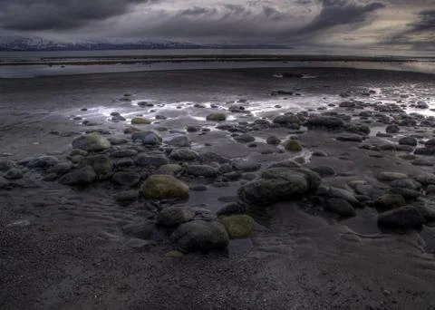 Rocky beach with storm cloud Stock Photos