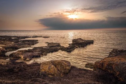 Rocky beach at sunset Stock Photos