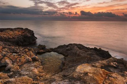 Rocky beach at sunset Stock Photos