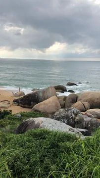 Rocky beach under cloudy sky Stock Photos
