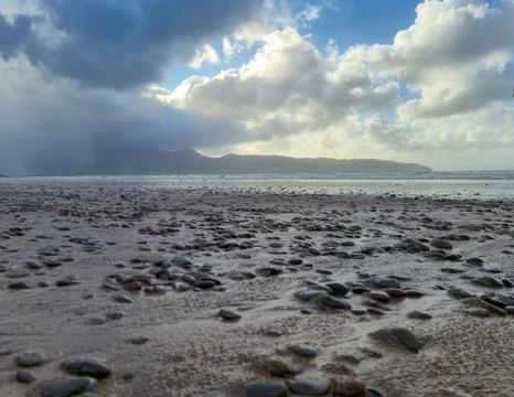 Rocky beach under dramatic cloudy sky Stock Photos