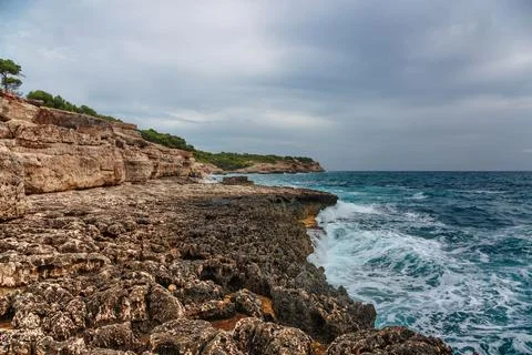 Rocky beach under a gloomy dramatic sky Stock Photos