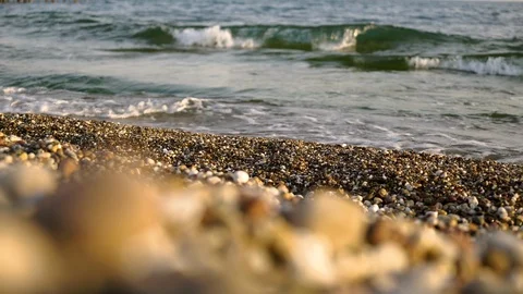 On a rocky beach, the waves splashing. The bottom view through the blur. Video stock 91009053