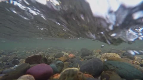 The rocky bottom of a mountain river with a fast current and clear water. 動画素材 301693232