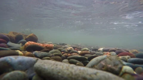 The rocky bottom of a mountain river with a fast current and clear water. 動画素材 301694122