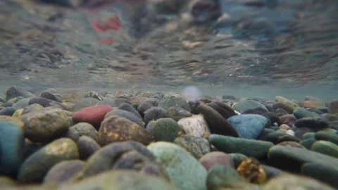The rocky bottom of a mountain river with a fast current and clear water. 動画素材 306018678